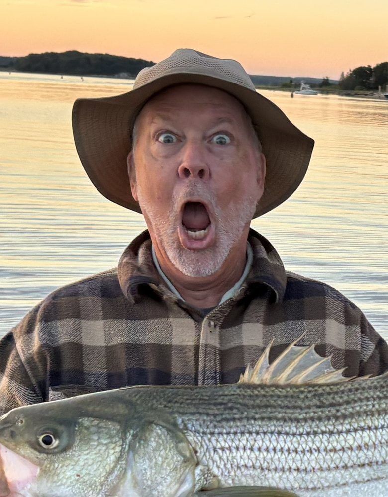 Portrait of Hunt Allard in a sun hat, holding a large fish on a boat